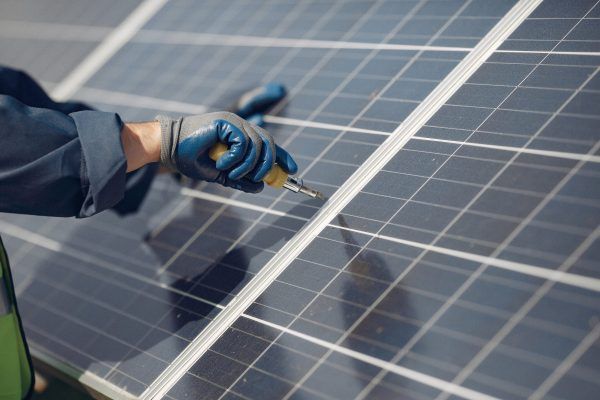 Man in a white helmet near a solar panel Engineer in a white helmet. Man near solar panel.